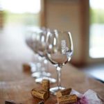 Photo of a wine glass, corks, and a wine-stained napkin